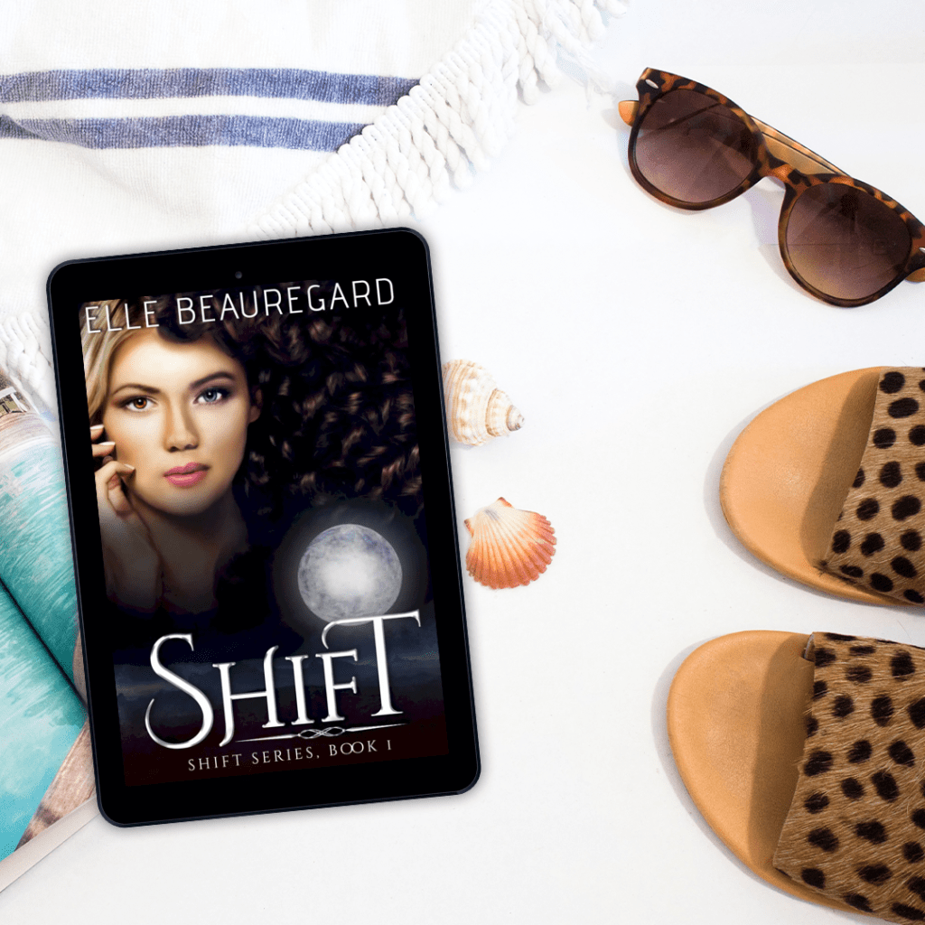 Shift cover on an e-reader among beachy things like sunglasses, sandals, and shells